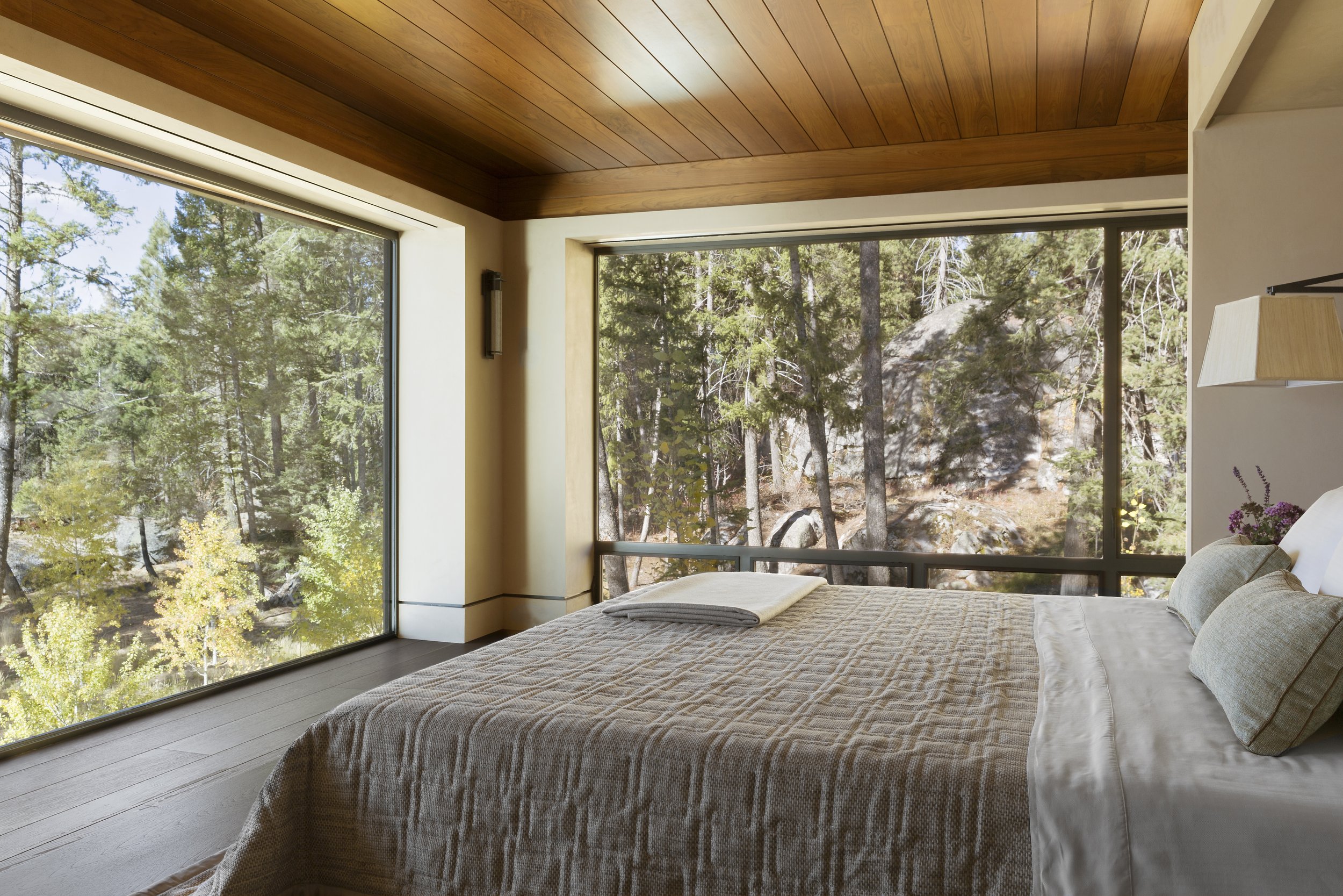Modern Bedroom with Forest View and Wooden Ceiling in McCall, Idaho Home