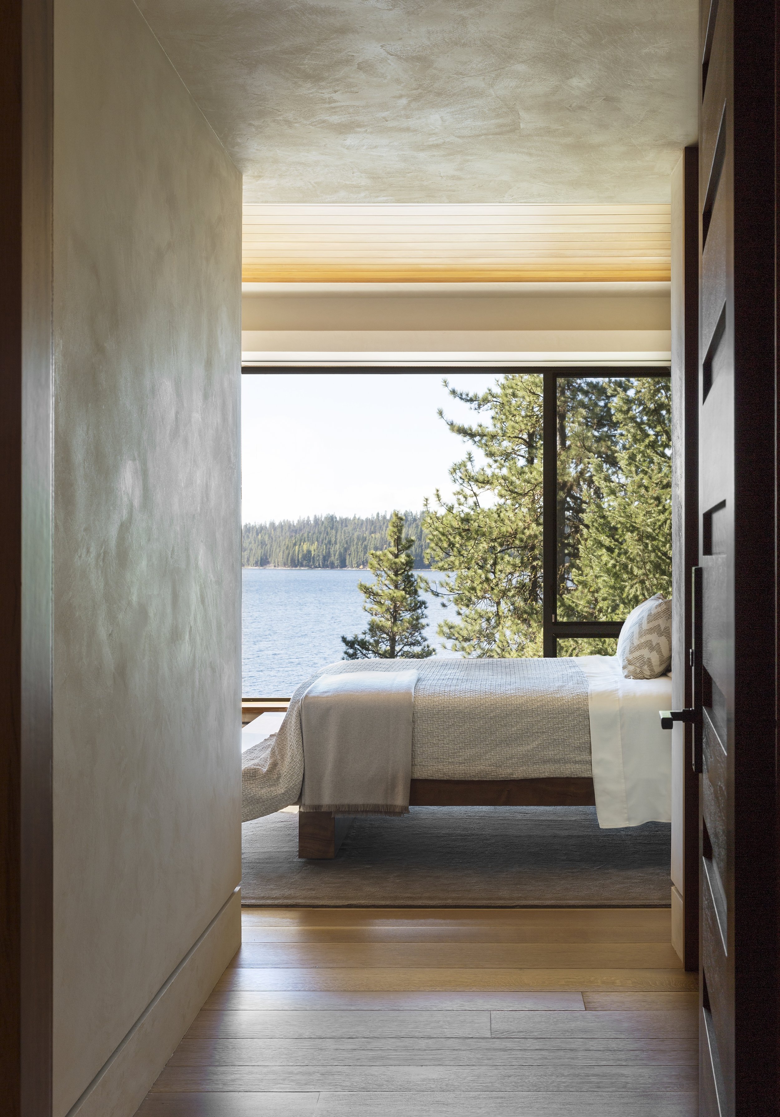 Modern Bedroom with Lake View and Neutral Bedding in McCall, Idaho Home